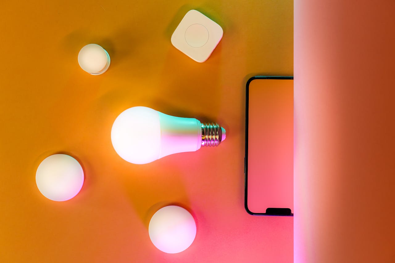 Modern smart home lighting setup featuring a glowing LED bulb and gadget on an orange background.